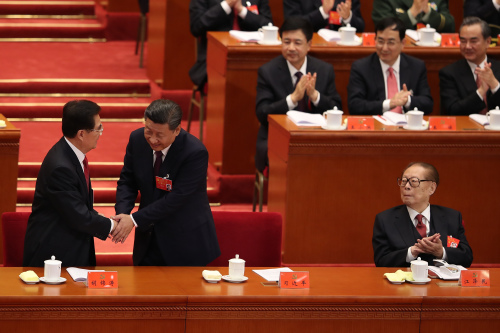 習近平宣讀完十九大報告後，回到主席臺與胡錦濤握手。