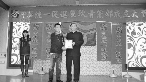 统促党狄青党部主委孔庆骏（左二）涉暴力恐吓。图为白狼张安乐（右）于两年前颁发政党证书给孔庆骏。