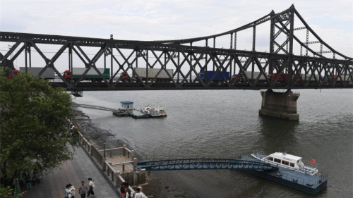 这座已经经历了80年风霜的公路铁路友谊桥是中国通往朝鲜的主要贸易通道，通过这座桥，中国向朝鲜输送了百分之七十到八十的物资。(16:9) 