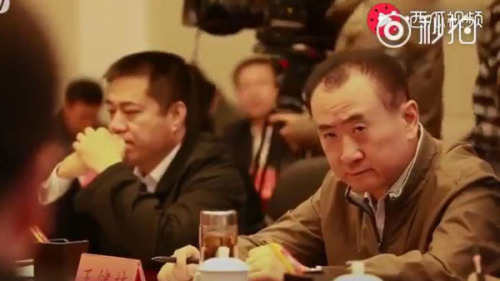 丹寨县长提到截留所有利润时，王健林瞪大眼睛盯着他看。（视频截图） 