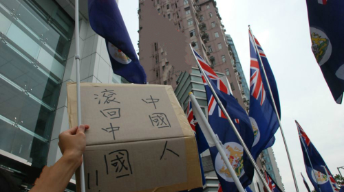 中港矛盾激化，示威人士在中联办门外高举反中标语及港英时代的“龙狮旗”。（图片来源：VOA） 