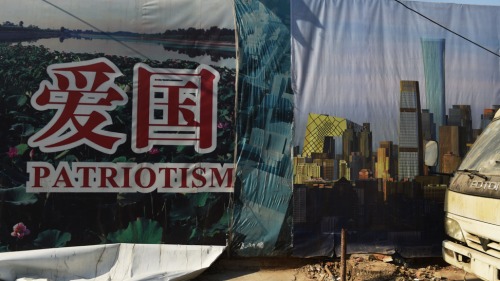 2015年2月10日，北京一處建築工地，一張海報壞損後露出了之前的愛國主義宣傳海報。