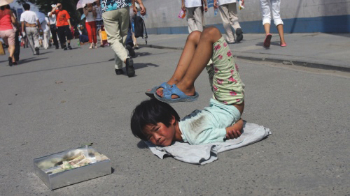 中国拐卖儿童及贩卖人口问题严重，图为中国被拐卖儿童被强迫在街头卖艺求生。