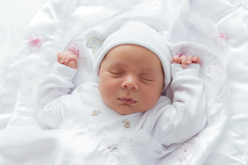 仰睡时的宝宝会把手高举在头上，呈现逗趣的投降睡姿！