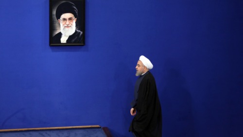 伊朗总统哈瓦尼·鲁阿尼（Herman Rouhani）于2015年8月29日在首都德黑兰举行的新闻发布会上致辞时，走过伊朗最高领袖阿亚图拉·阿里·哈梅内伊的画像。