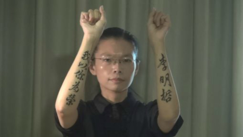 李净瑜召开记者会，秀出双手“李明哲我以你为荣”的刺青，强调这是一场“政治大戏”，丈夫是“被认罪”。