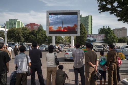 9月16日，在平壤平和汽車廣告牌旁，人們正觀看大屏幕上播放的朝鮮發射火星12型導彈的鏡頭。