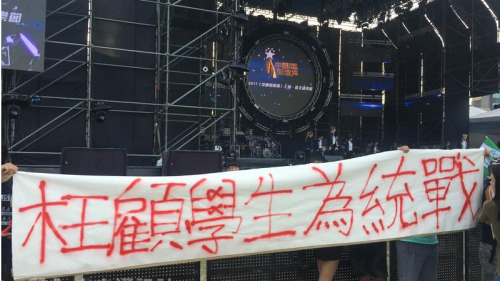 大陆选秀节目“中国新歌声”24日在台湾大学举办活动，有民众到场拉开白布条表达不满。