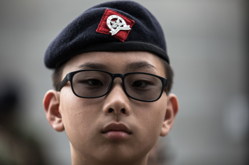 香港少年頭戴青少年軍的帽子與徽章