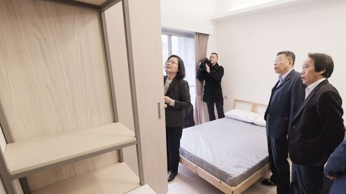 总统蔡英文（左）26日下午到位于台北市松山区的健康公宅视察，台北市长柯文哲（右2）、副市长林钦荣（右）陪同。图为蔡总统仔细查看公宅内家具。