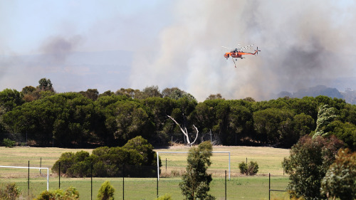 澳洲維多利亞州、南澳及塔斯馬尼亞州天氣酷熱，政府方已經頒布全面禁火令，墨爾本郊區也頻傳出野火失控，有不少民眾房舍被燒燬。圖為救援人員駕直升機救火。(16:9)