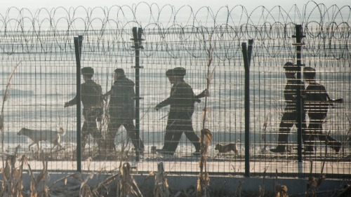 朝鲜士兵在朝鲜小镇新义州与对面的中国边境城市丹东间的边界围栏附近巡逻