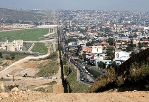 2007年3月的美墨边界。右侧是墨西哥蒂华纳，人口稠密、建筑众多；左侧是美国加州圣地亚哥。