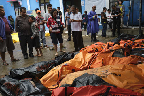 2018年12月23日，印尼海啸过后，人们在临时停尸处识别罹难亲戚的遗体。