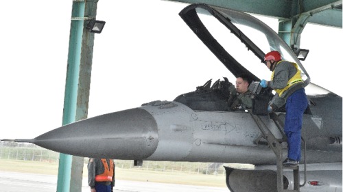 2018年1月30日，一名飛行員和一名士兵在臺灣臺東市空軍基地舉行的年度演習中檢查F-16戰鬥機。