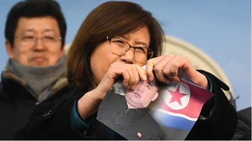 2018年1月24日，首尔国民大会举行的新闻发布会上，一名脱北者撕毁金正恩的照片。