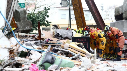 花蓮強震搜救行動11日宣布結束，搜救人員在大樓前向罹難者鞠躬默哀。