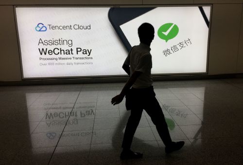 2017年8月21日，一名男子在香港国际机场的中国腾讯公司微信社交媒体平台广告前经过。