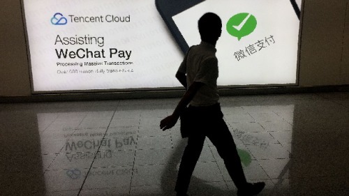 2017年8月21日，一名男子在香港国际机场的中国腾讯公司微信社交媒体平台广告前经过。