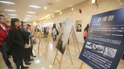 「2018國際大屠殺紀念日」活動25日在國家圖書館舉行，許多民眾仔細瀏覽現場展出的相關事件內容介紹。