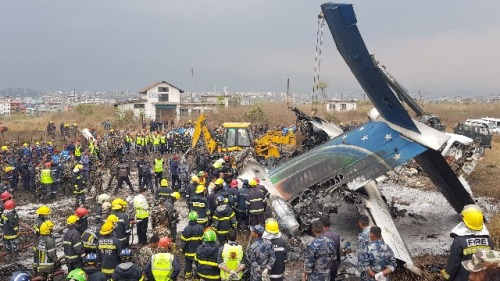2018年3月12日，尼泊爾救援人員聚集在加德滿都國際機場附近墜毀的飛機殘骸周圍。