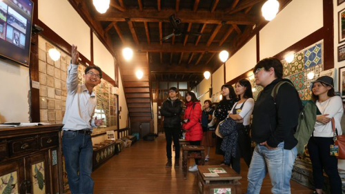 台湾花砖古厝创办人徐嘉彬（左）假日时也身兼导览员，为来访民众解说花砖历史与故事。