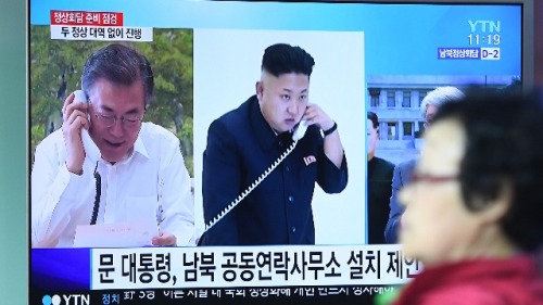 2018年4月25日，一名婦女經過首爾火車站的一個新聞屏幕前，畫面顯示韓國總統文在寅和朝鮮領導人金正恩通話鏡頭。