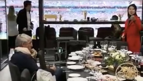 前中国国家队主教练米卢在球场看台的一个豪华包厢里面休息，包厢内的桌子上摆满食物。（视频截图）