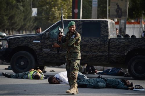 2018年7月22日，在喀布爾發生自殺式襲擊事件後，一名阿富汗安全部隊成員站在受害者身體附近。