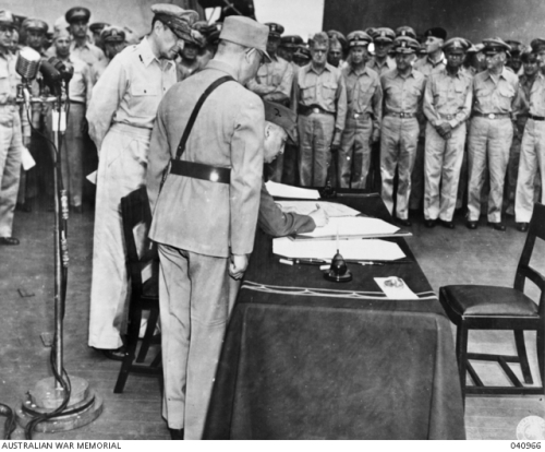 1945年9月2日，徐永昌将军在日本投降书上签字。身后是麦帅麦克阿瑟。