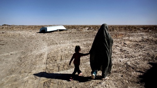 2015年2月2日，一名伊朗妇女与她的女儿走过一条废弃的小船旁。