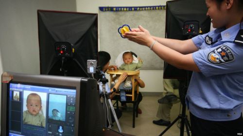 中國江蘇南京一名7個月大的幼童正在派出所裡拍攝他的居民身份證照片。