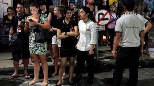 8月5日，在龙目岛发生大地震后，外国游客和酒店工作人员在巴厘岛首都登巴萨撤离后站在街上。