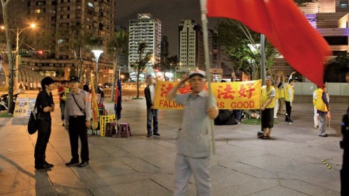 台北101大楼前，有一群手持五星旗的爱国同心会成员长驻。
