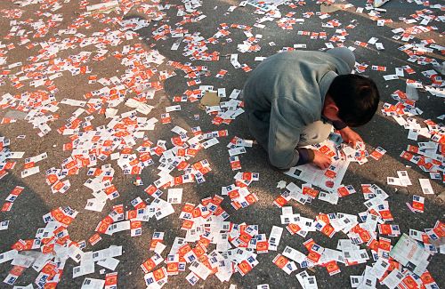 一名彩民希望在被扔掉的彩票形成的“海洋”中意外发现一张被漏掉的中奖票。