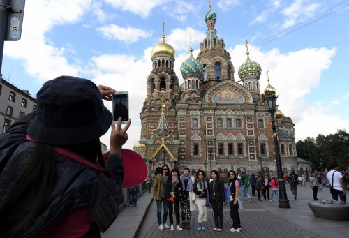 中国游客在圣彼得堡的一处教堂前拍照留念。