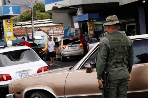 2018年9月4日，一個士兵在委內瑞拉的一個加油站排隊維持秩序，大批民眾排隊加油。