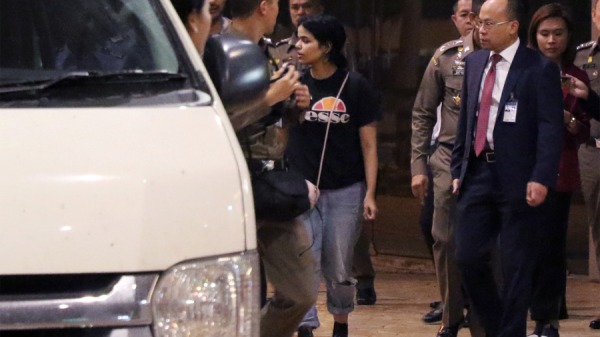 2019年1月7日，18岁的沙特女子奎農(中)在曼谷国际机场被泰国移民官和联合国难民事务高级专员办事处（UNHCR）官员护送