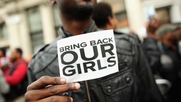 2014年5月9日，在英国伦敦尼日利亚大厦外的一名抗议者拿着一个标志，上面写着“带回我们的女孩”（Bring back our girls）