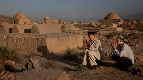新疆维吾尔人在一个亲人的坟墓祈祷