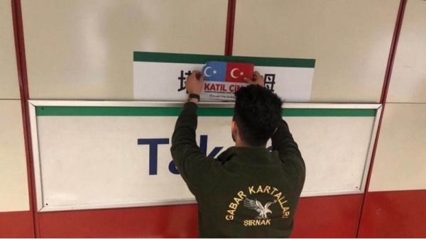 位參與公民不服從運動的土耳其民眾，在中文站牌上覆蓋寫有「中國劊子手」字樣。