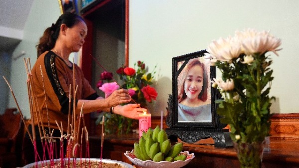 2019年10月26日，越南Nghe An省的房屋内，亲人在Bui Thi Nhung的肖像前燃香，她被认为是近日死于英国39人中的一员。