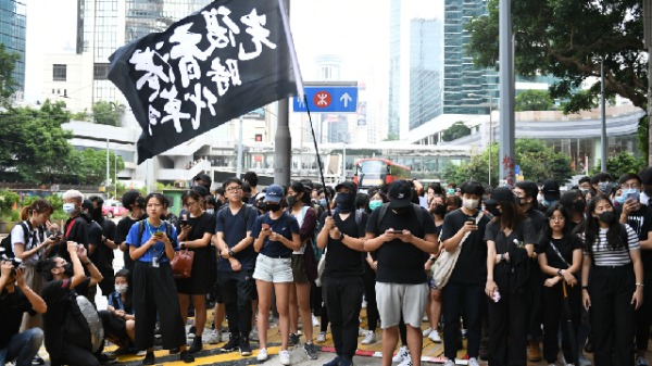 2019年10月9日，香港抗议者聚集在高等法院大楼外，高举黑旗，上写着“光复香港，时代革命”。