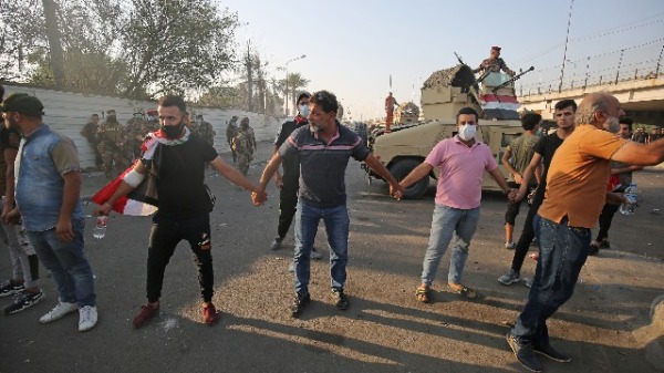 2019年10月3日，伊拉克首都巴格达中央Tayeran广场举行的反对腐败的示威游行中，伊拉克示威者牵手组成人链。