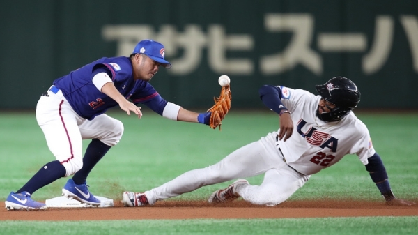 世界12强棒球赛复赛，中华队15日在东京巨蛋交手美国队，1局下美国队艾德尔（Jordon Adell）（右）敲出安打上到一垒，接着盗垒上二垒。