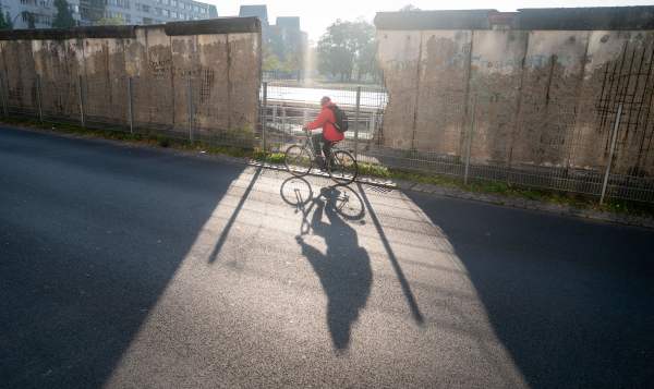 2019年11月1日，柏林墙的遗址前，有人骑自行车经过。德国将于2019年11月9日庆祝柏林墙倒塌30周年。