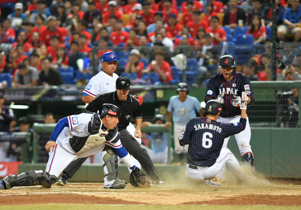 6局上，日本打者击出中外野深远二垒安打，送回垒上跑者坂本勇人（前右），为日本队再添一分。