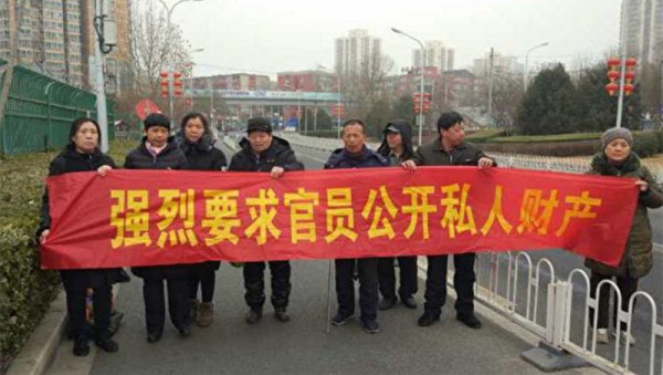 新年長假最後一天，在京上訪的訪民在北京南站，拉起寫有「強烈要求官員公開私人財產」的橫幅。（維權網）