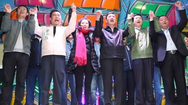 民進黨籍候選人余天（右 3）傍晚與黨主席卓榮泰（右2）、妻子李亞萍（左3） 等人現身競選總部，手牽手開心齊聲歡呼。