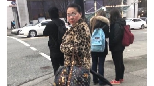一个华人大妈，手里拿着一个高调的LV包包，跟人要钱。被网友拆穿是骗局后，还拿雨伞打人！